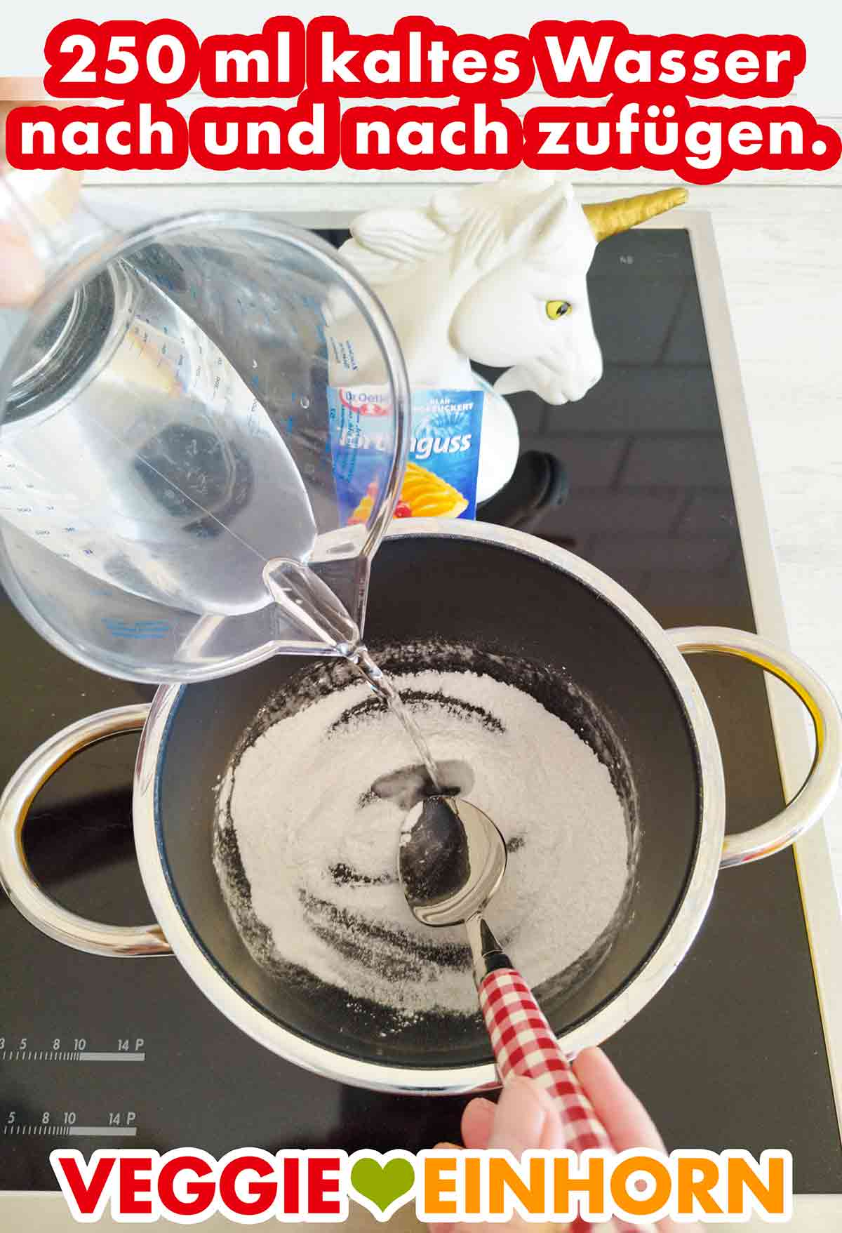 Wasser wird aus einem Messbecher in den Topf mit dem Tortenguss Pulver gegossen.