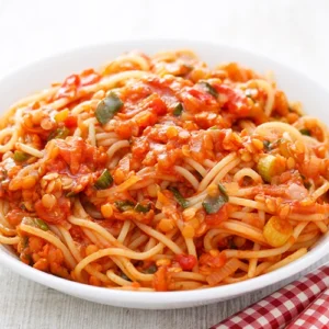 Nahaufnahme von Spaghetti mit veganer Linsenbolognese auf einem weißen Teller.
