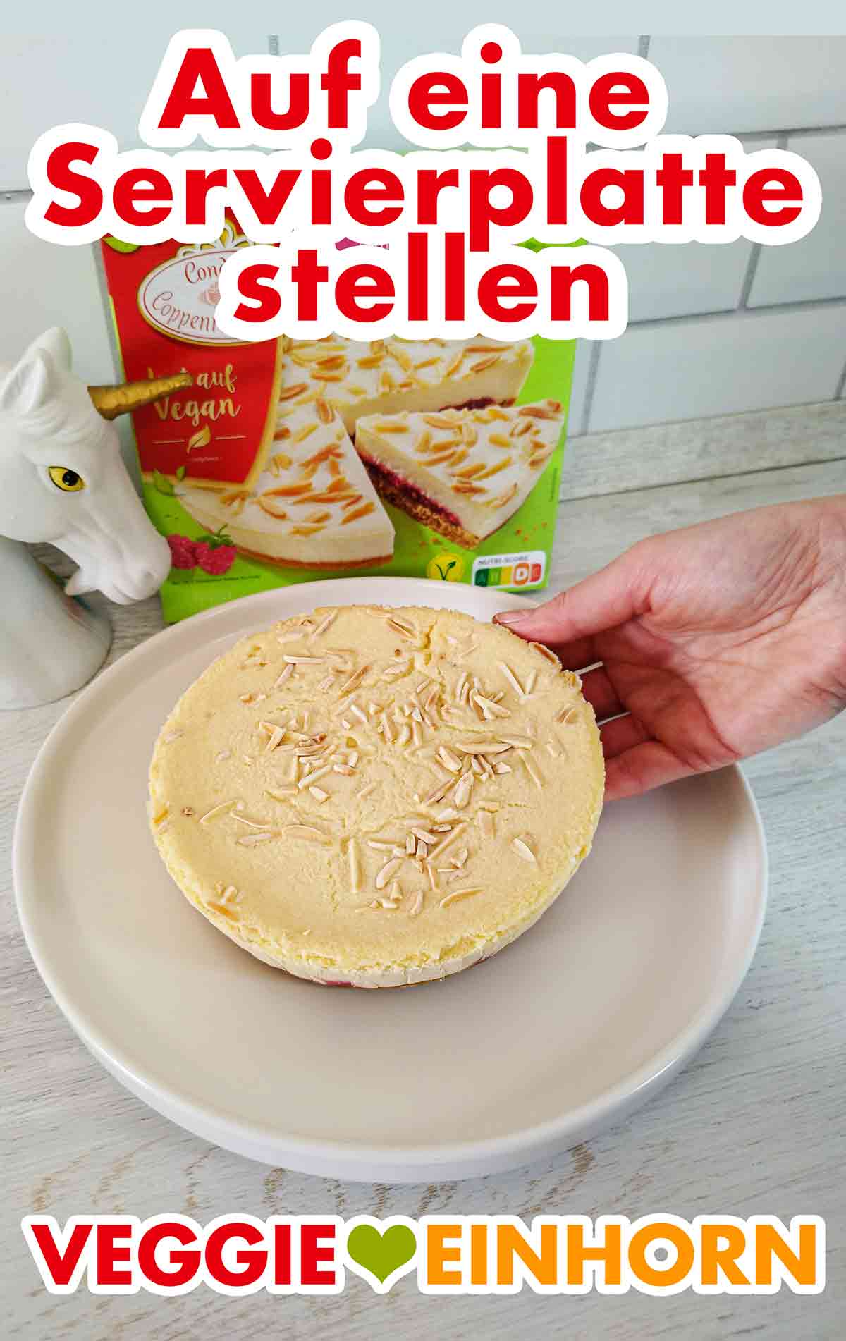Der vegane Himbeer Mandel Cheesecake von Coppenrath und Wiese wird auf eine Servierplatte gelegt