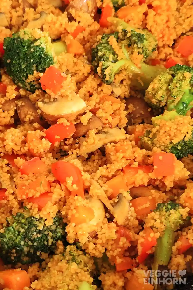 Nahaufnahme der Couscouspfanne mit Gemüse, zu sehen sind Brokkoli, Pilze, Möhren und rote Paprika.