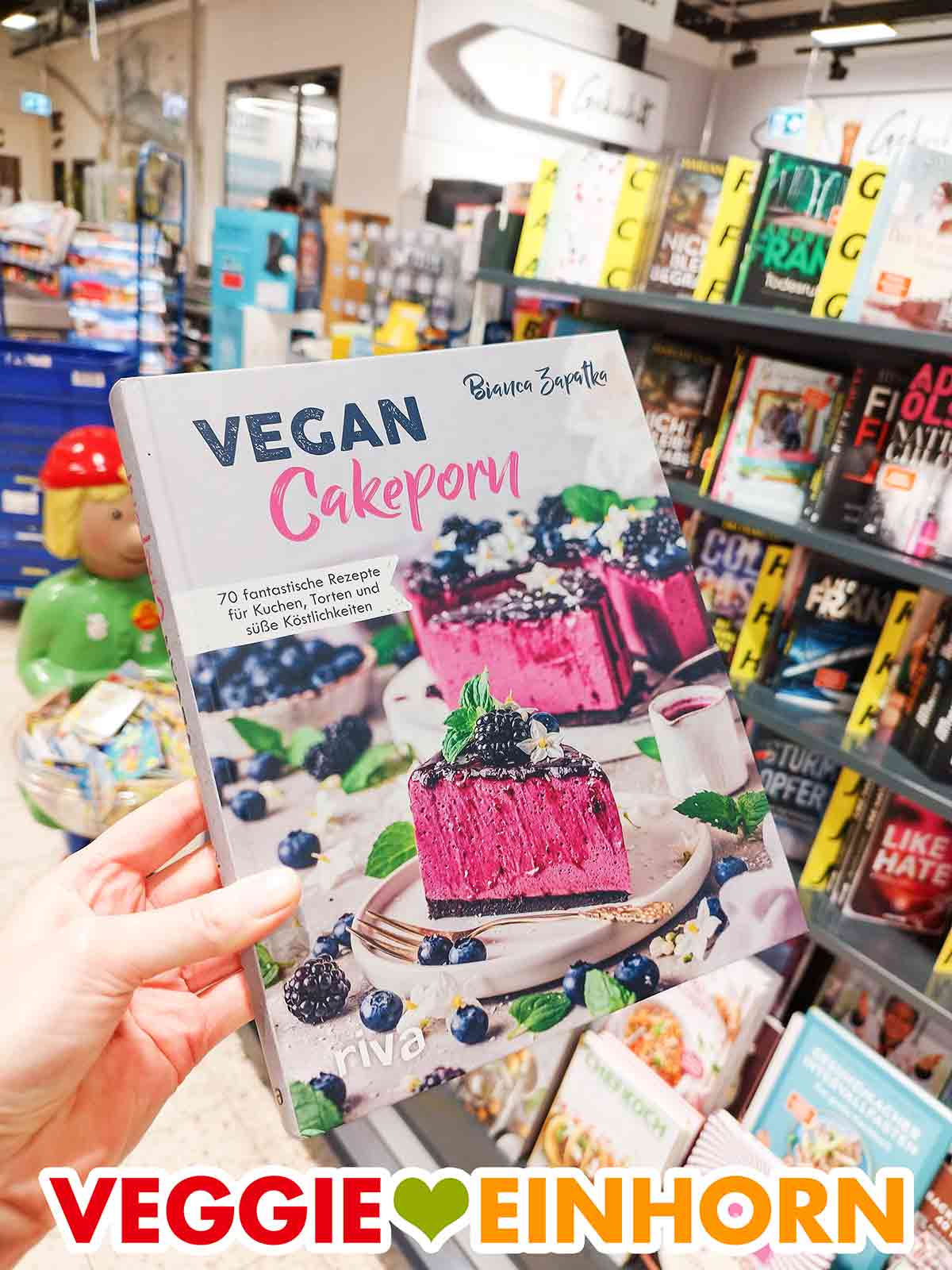 Eine Hand hält das Buch Vegan Cakeporn von Bianca Zapatka im Marktkauf