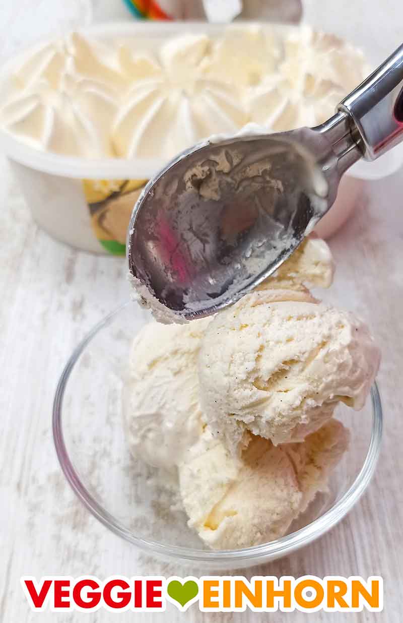 Vanilleeiscreme wird mit einem Eisportionierer in eine Dessertschale gegeben