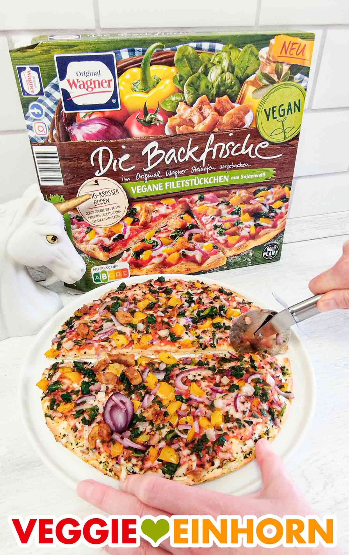 Die Backfrische Pizza mit veganen Filetstückchen von Wagner wird mit dem Pizzaroller geschnitten