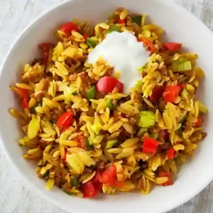 Teller mit veganer Kritharaki Hackfleisch Pfanne mit Gemüse und veganer Joghurtsoße