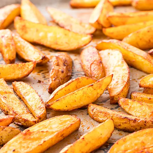Einfache Kartoffel Wedges aus dem Ofen auf einem Backblech.