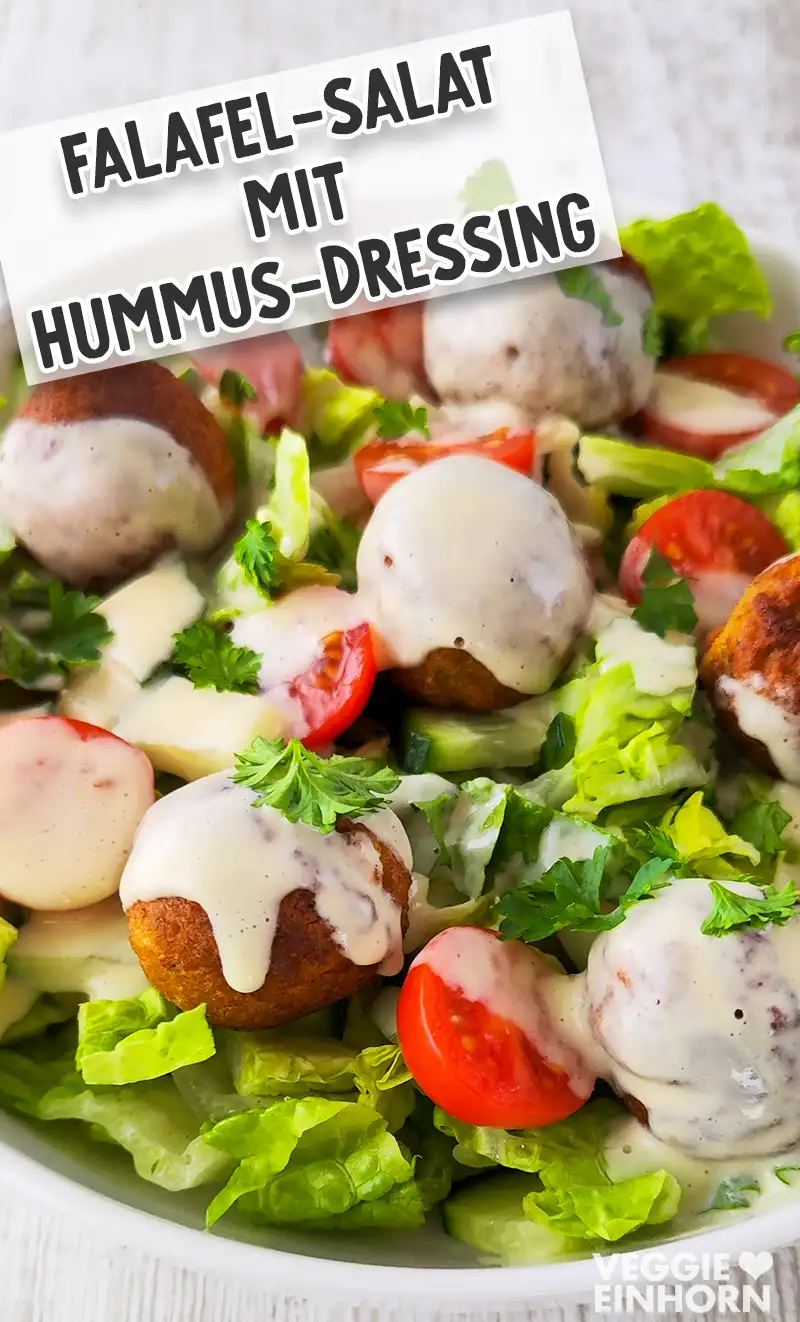 Falafelsalat mit veganem Hummus-Dressing darüber verteilt.
