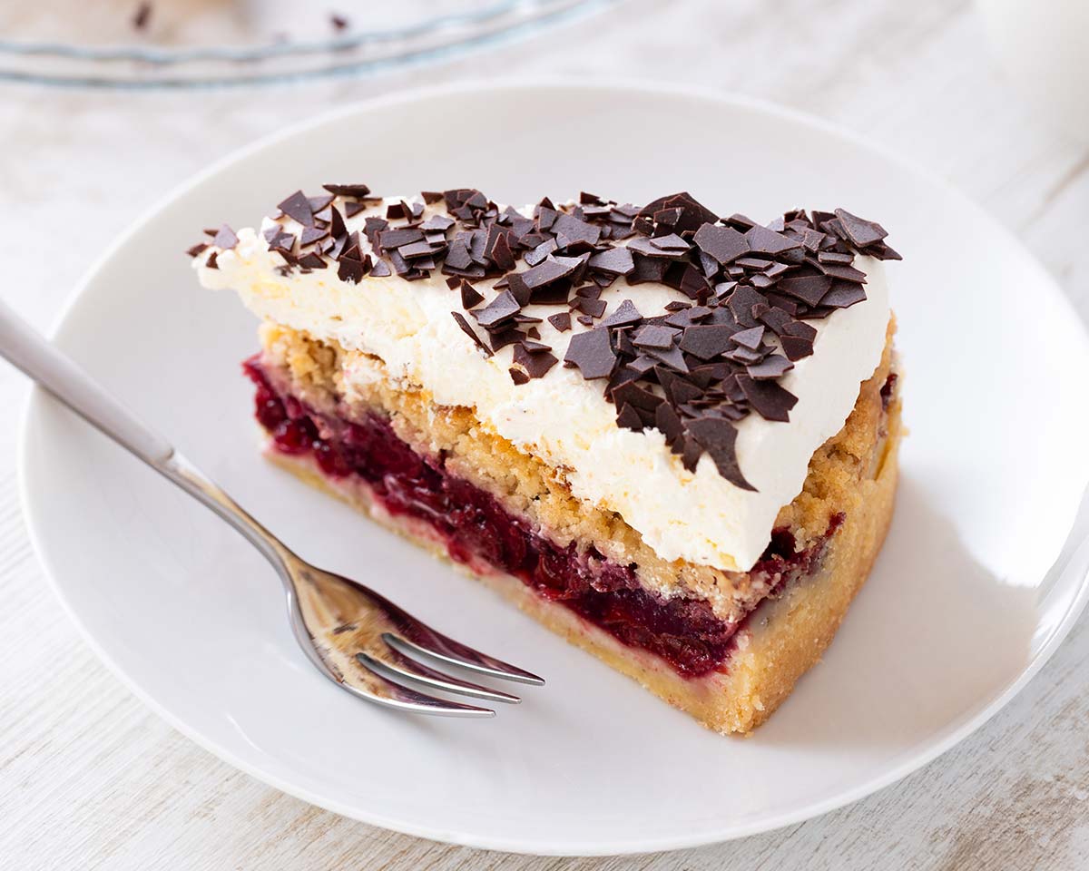 Ein Stück veganer Feuerwehrkuchen auf einem Kuchenteller. Daneben liegt eine Kuchengabel.