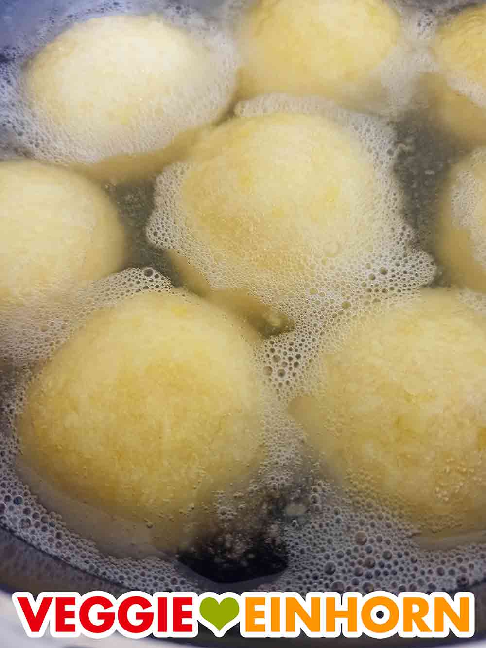 Die Sonntagsknödel steigen im Topf nach oben. Die gegarten Kartoffelknödel steigen and die Oberfläche.