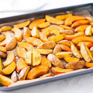 Kürbis- und Kartoffelspalten aus dem Ofen auf einem Backblech.
