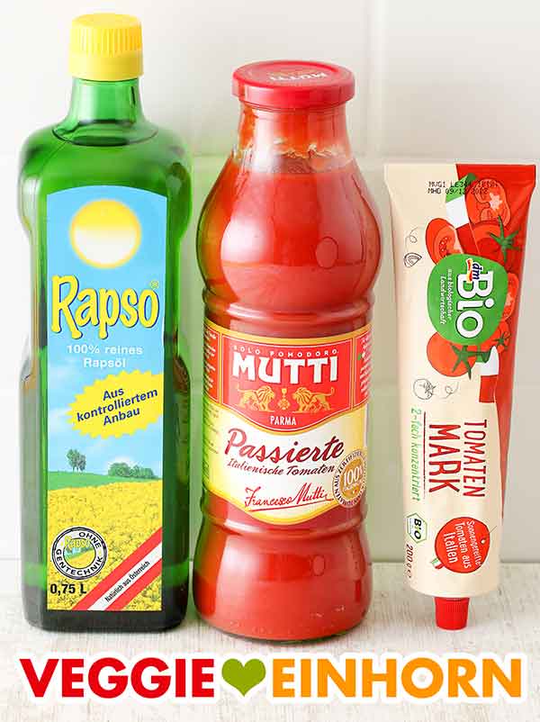 Eine Flasche Rapsöl, eine Flasche passierte Tomaten und eine Tube Tomatenmark