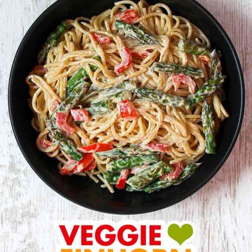 Ein Teller Pasta mit gebratenem grünen Spargel und roter Paprika