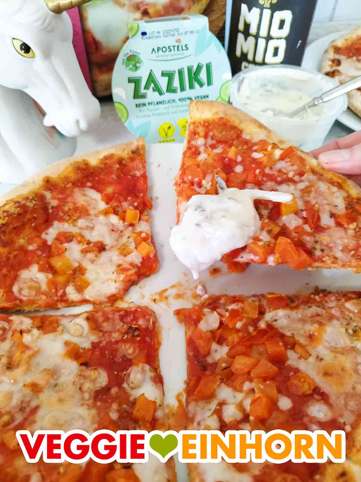 Ein Stück vegane Pizza mit veganem Zaziki von Apostels