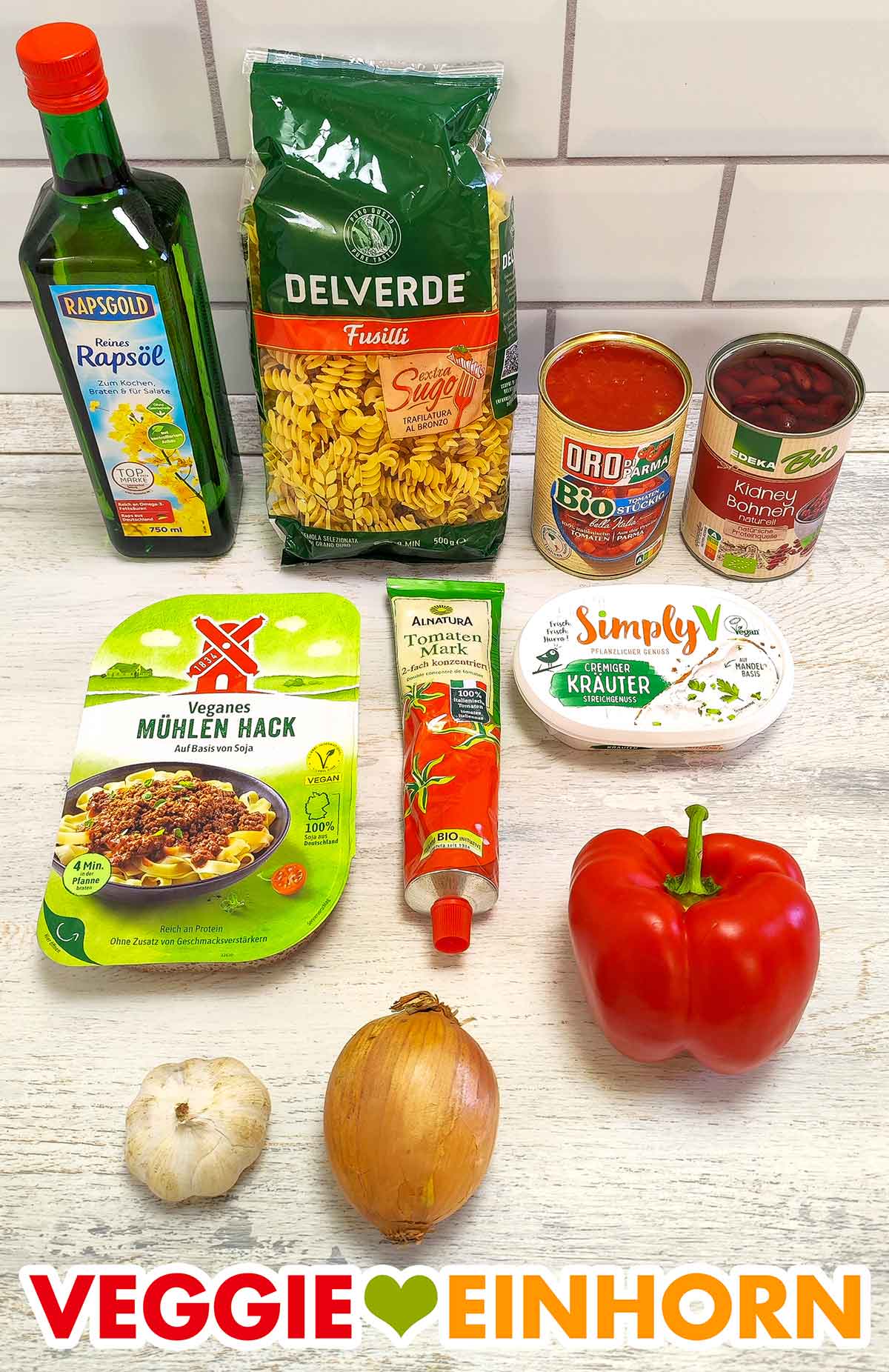 Öl, Nudeln, Tomatenstücke, Kidneybohnen, veganes Hack, Tomatenmark, veganer Kräuterfrischkäse, rote Paprika, Knoblauch, Zwiebel