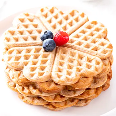 Vegane Waffeln im Herzchenmuster mit Beeren garniert als Symbolbild für die Kategorie Rezepte für vegane Waffeln.