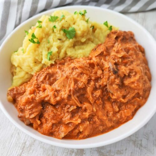 Ein Teller mit veganer Sauerkrautpfanne und Kartoffelpüree.