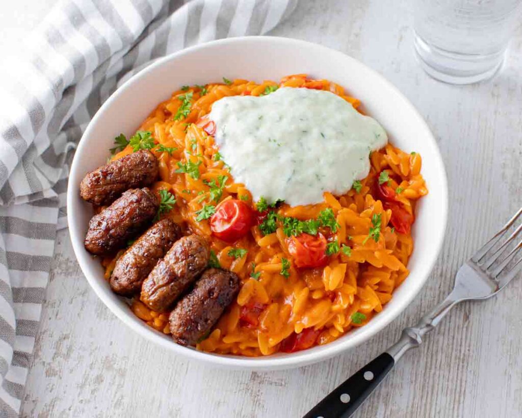 Tomaten Kritharaki mit veganen Cevapcici und Tzatziki Tomaten Kritharaki mit veganen Cevapcici und Tzatziki
