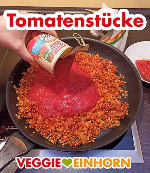 Tomatenstücke aus der Dose werden zugefügt