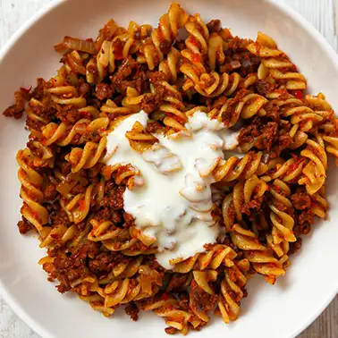 Türkische Nudeln mit veganer Joghurtsoße auf einem Teller.