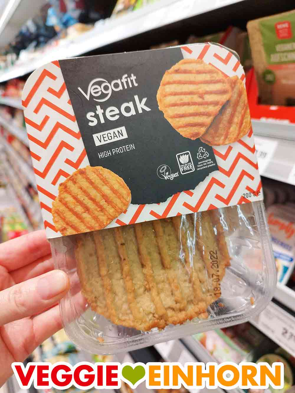 Eine Hand hält eine Packung Vegafit Steaks im Supermarkt