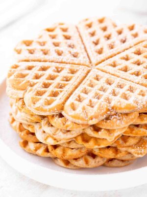 Mehrere vegane Dinkelwaffeln auf einem Teller, seitlich fotografiert.