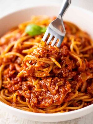 Grünkernbolognese mit einer Gabel auf einem Teller