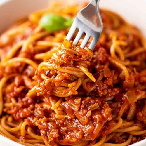 Grünkernbolognese mit einer Gabel auf einem Teller