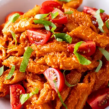 Vegane Penne mit Tomatensoße und frischem Basilikum als Symbolbild für die Kategorie vegane italienische Rezepte.