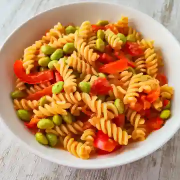 Vegane Nudelpfanne mit Fusilli, Edamame, roter Paprika und Tomaten.