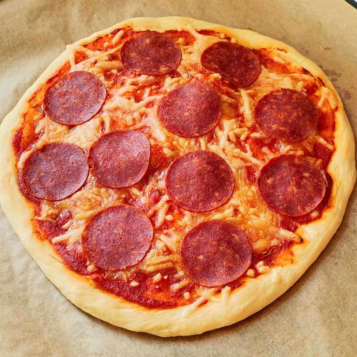 Runde vegane Pizza Salami auf einem Backpapier.