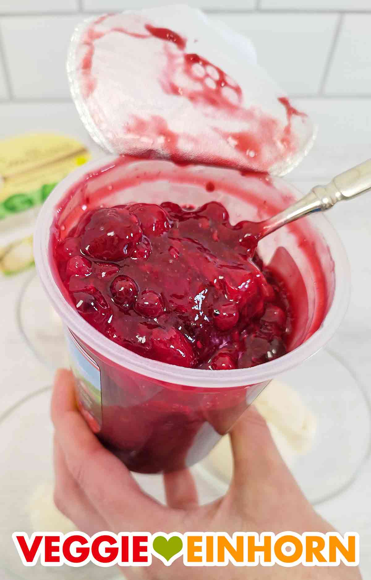 Löffel im Becher mit veganer roter Grütze von Dr. Oetker