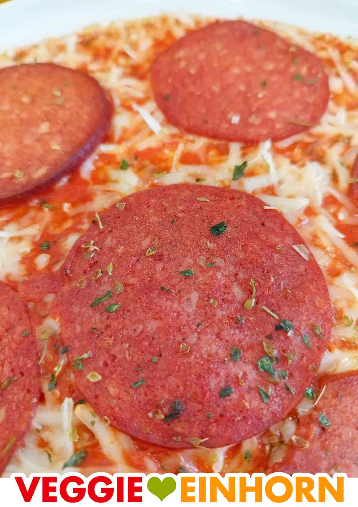 Nahaufnahme einer mit Oregano bestreuten veganen Salamischeibe auf der veganen Pizza Ristorante 