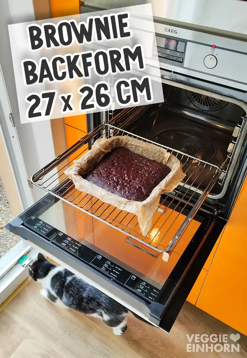 Eine Brownie Backform mit frisch gebackenen veganen Schokobrownies steht im geöffneten Backofen.