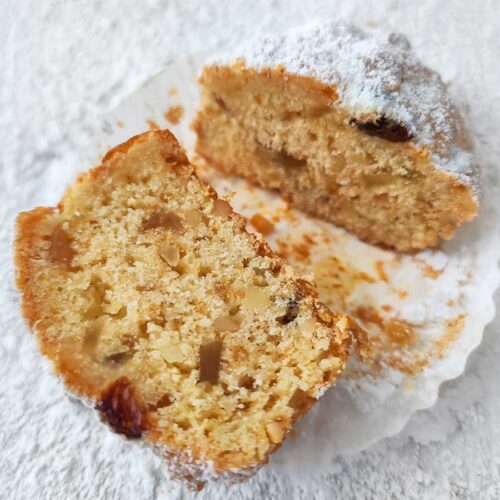 Zwei Hälften eines veganen Stollen Muffins auf heller Unterlage.