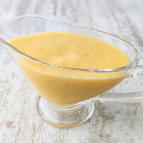 Vegane Vanillesoße serviert in einer Glas-Sauciere.