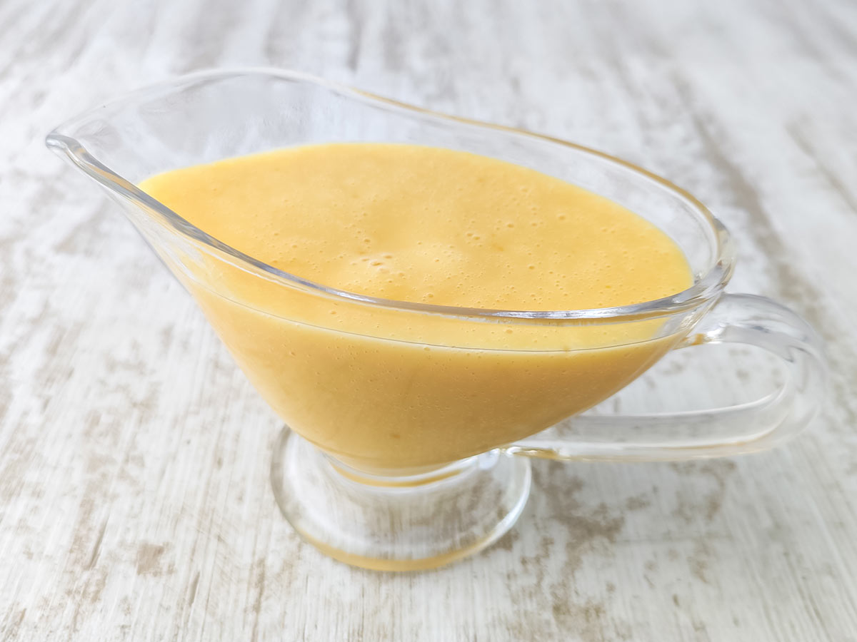 Vegane Vanillesoße serviert in einer Glas-Sauciere.
