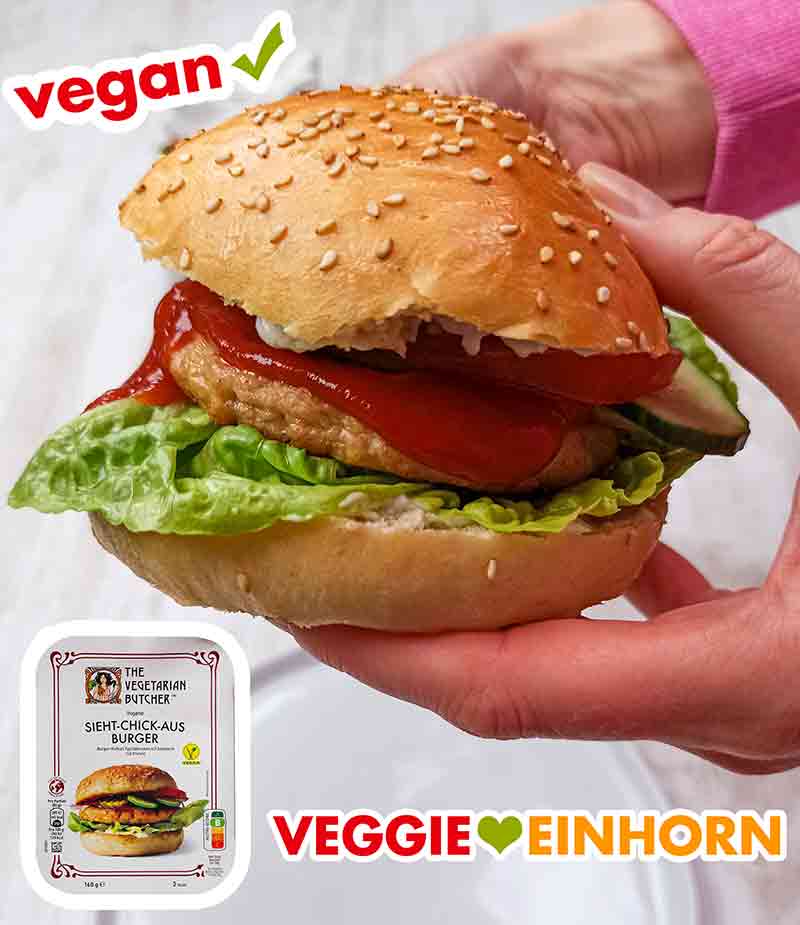 Zwei Hände halten einen veganen Chicken Burger mit Patty von The Vegetarian Butcher