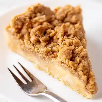 Ein Stück veganer Apfel Streuselkuchen mit Mürbeteig