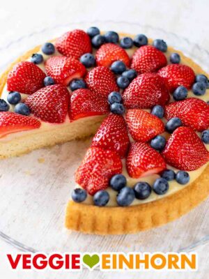 Veganer Erdbeer Blaubeer Kuchen mit Pudding auf einer Kuchenplatte