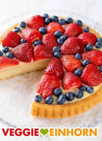 Veganer Erdbeer Blaubeer Kuchen mit Pudding auf einer Kuchenplatte