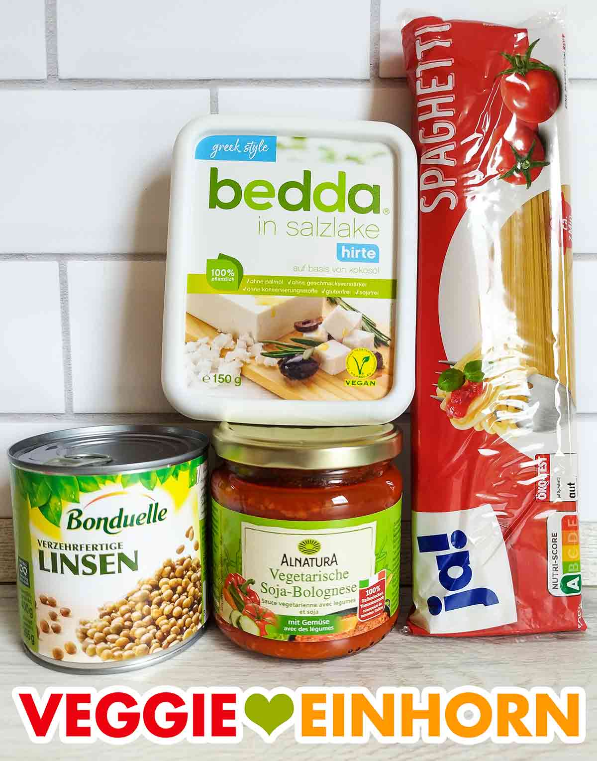 Veganer Feta, eine Dose Linsen, ein Glas vegane Soja Bolognese, eine Packung Spaghetti