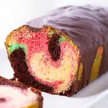 Nahaufnahme eines bunten veganen Papageienkuchens mit Marmormuster und Schokoglasur