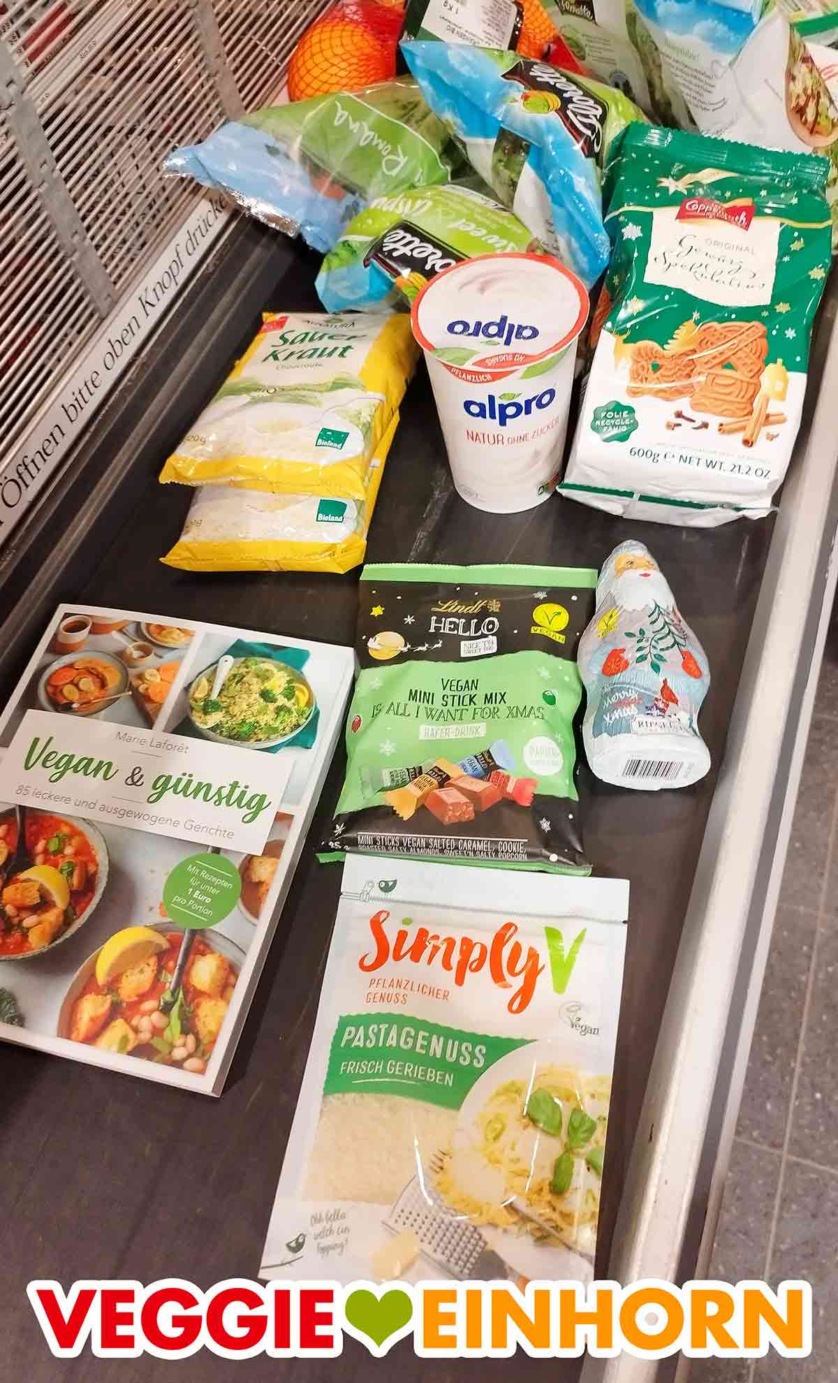 Veganer Riegelein Weihnachtsmann und andere vegane Produkte auf dem Kassenband im Supermarkt