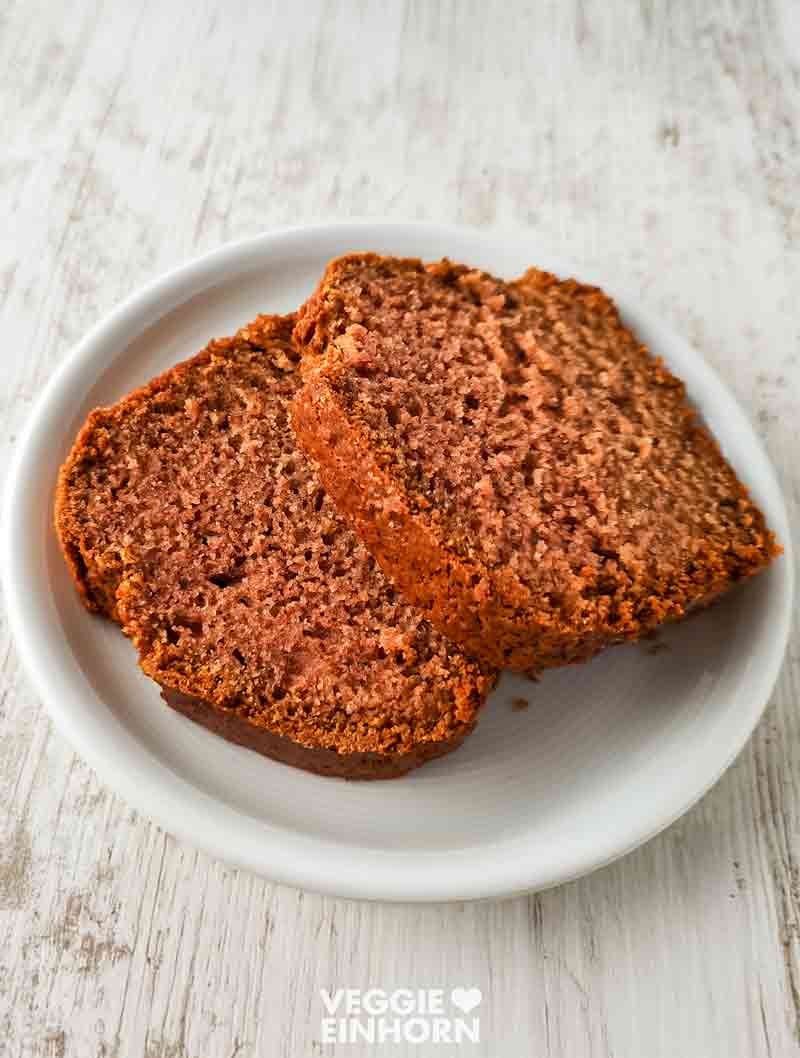 Zwei Stücke saftiger veganer Rührkuchen mit Apfelmus auf einem weißen Teller.