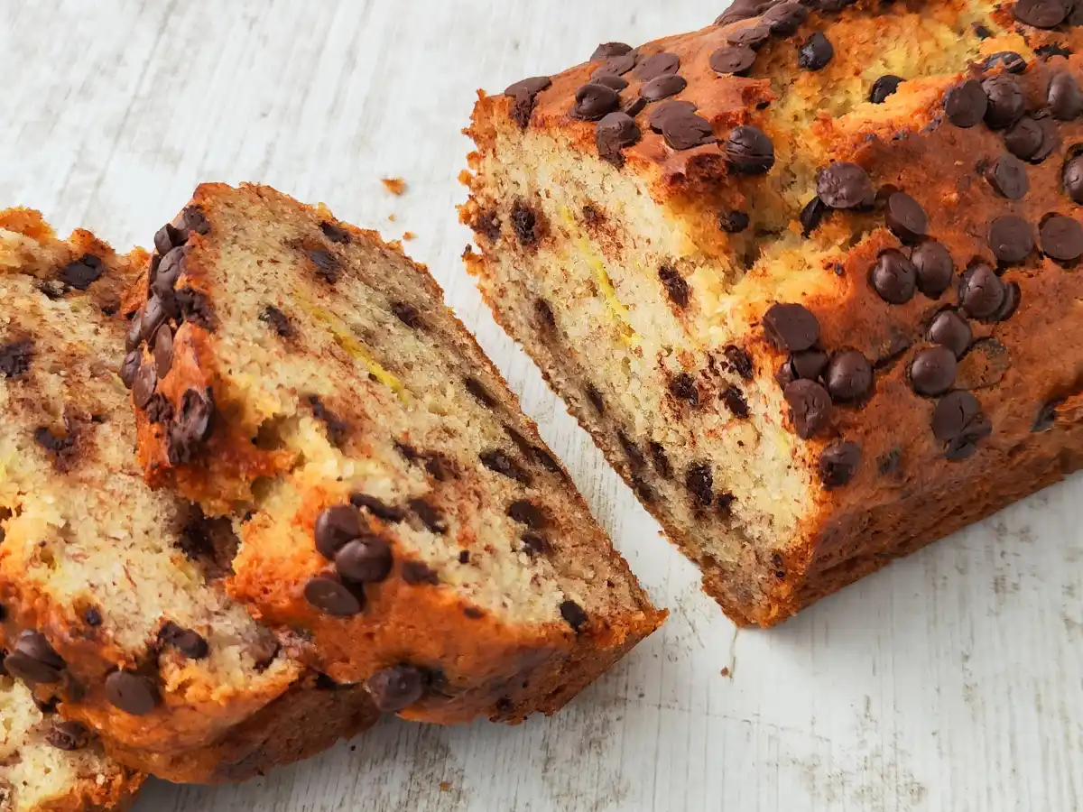 Saftiges veganes Bananenbrot mit Zartbitter-Schokotropfen, einige Scheiben sind abgeschnitten.