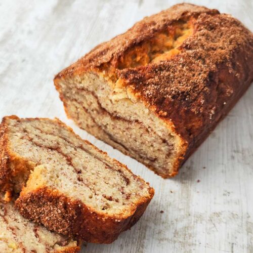 Veganes Bananenbrot mit Zimt, angeschnitten und mit Zimtzucker überzogen.