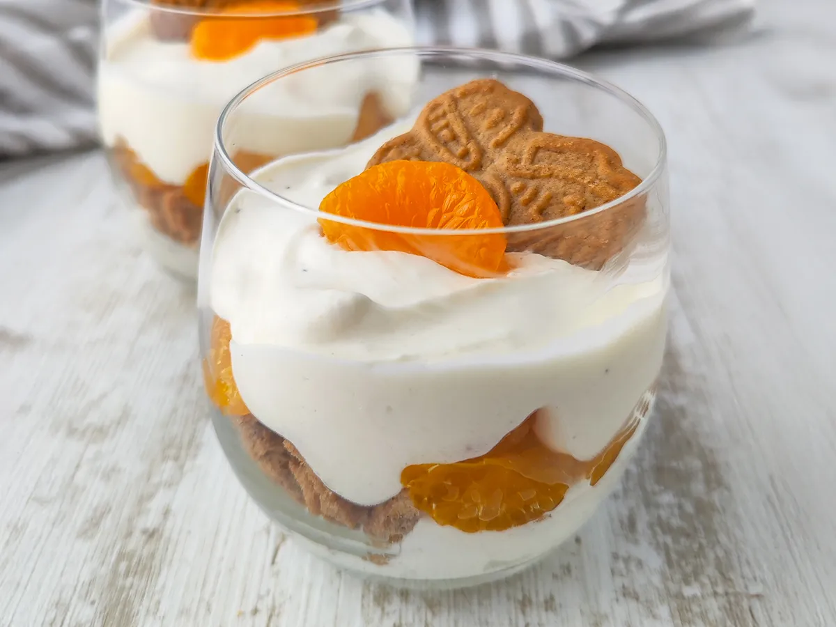 Ein Glas mit veganem Mandarinen Spekulatius Dessert, im Hintergrund steht ein weiteres Dessertglas.