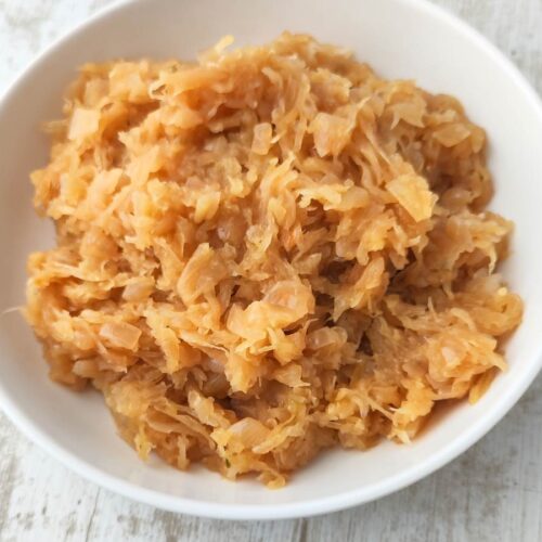 Veganes Sauerkraut in einer weißen Schüssel auf hellem Untergrund.