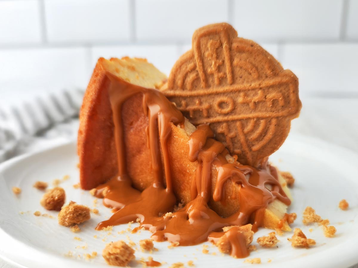 Ein Stück veganer Käsekuchen mit Lotus Biscoff Creme und Spekulatius Keks als festliches Dessert.