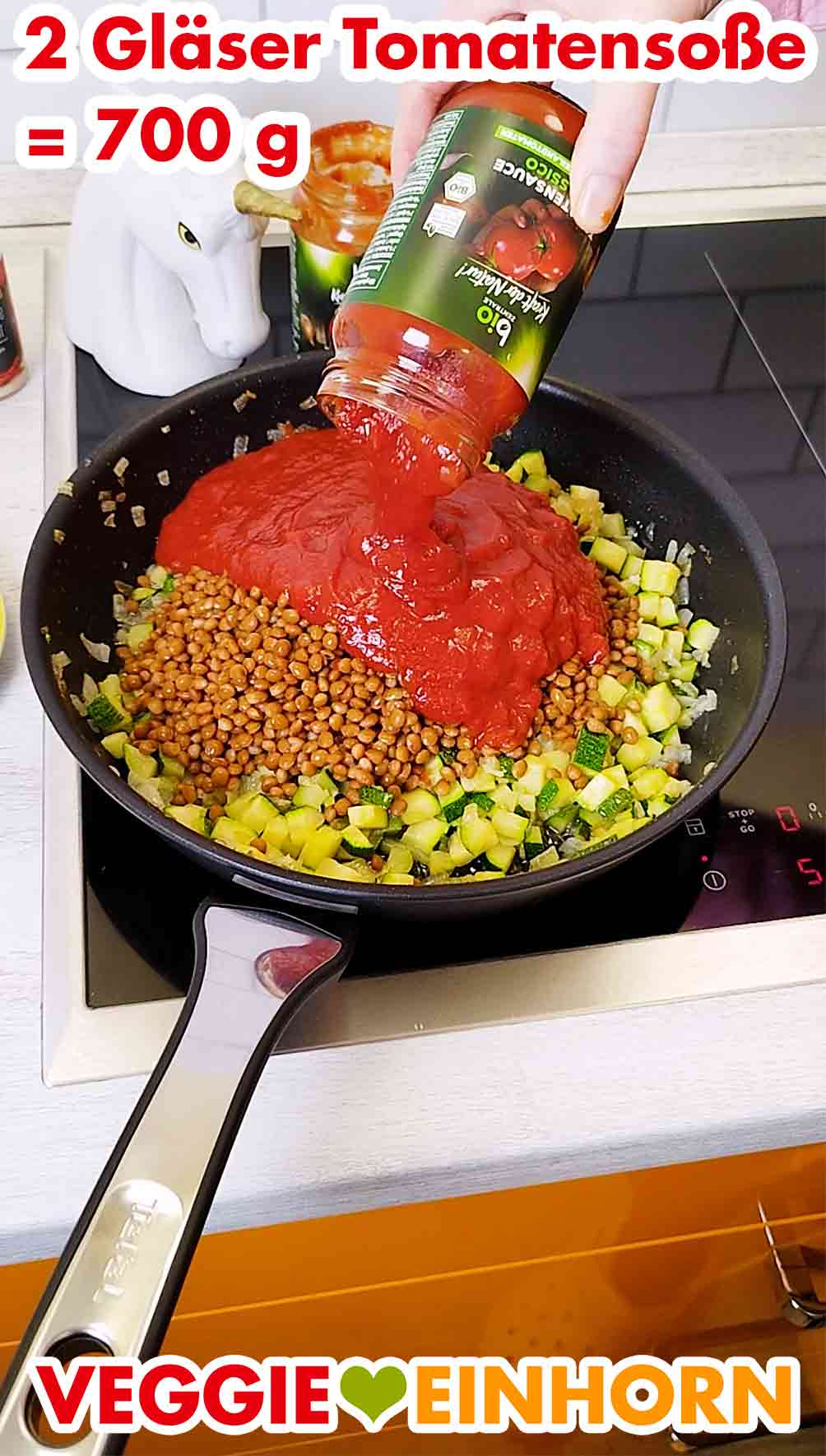 Vegane Tomatensoße aus dem Glas wird in die Pfanne gegeben