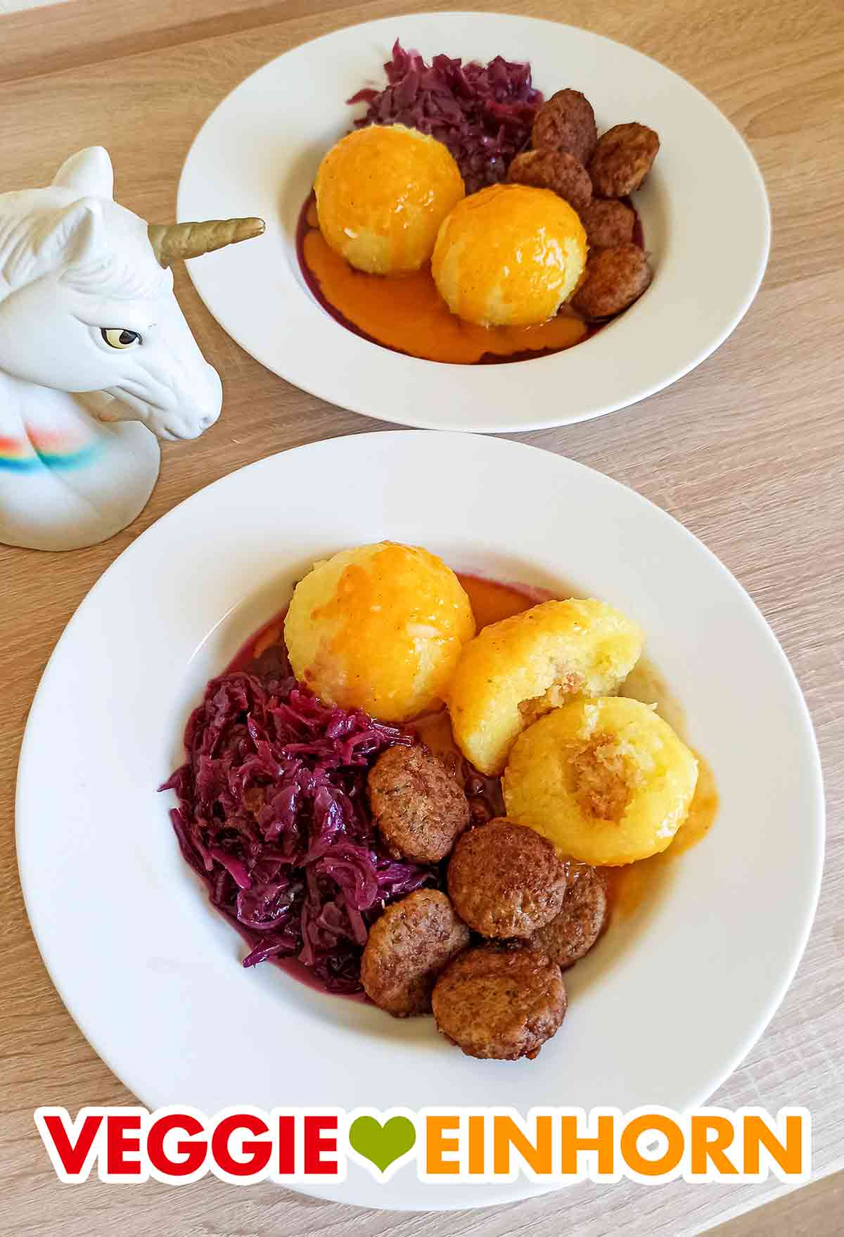 Ein schnelles leckeres Gericht mit fertig gekauften veganen Kartoffelknödeln. Zwei Teller mit veganen Sonntagsknödeln, veganer Bratensoße, Rothkohl und veganen Frikadellen